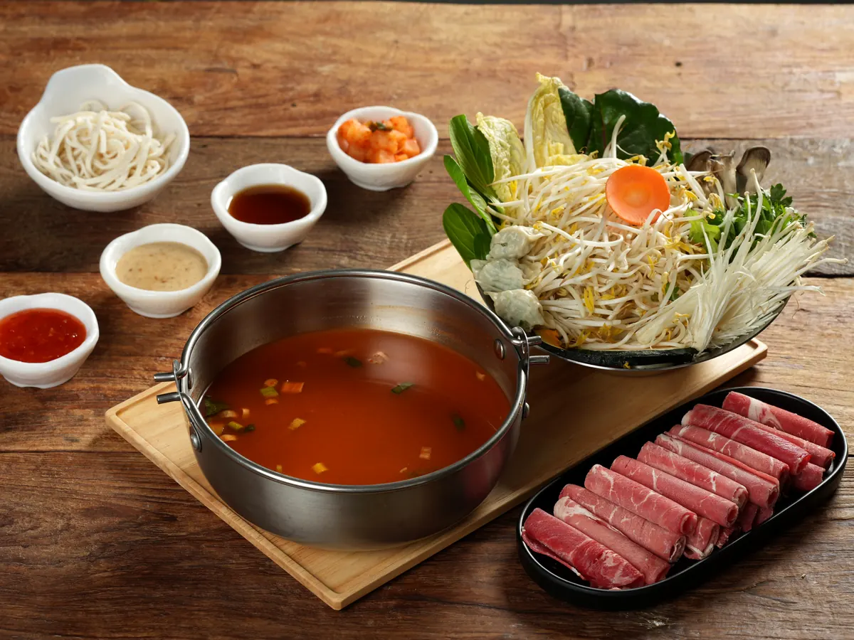 얼큰 육수 냄비와 소고기, 채소, 소스가 차려진 1인 상